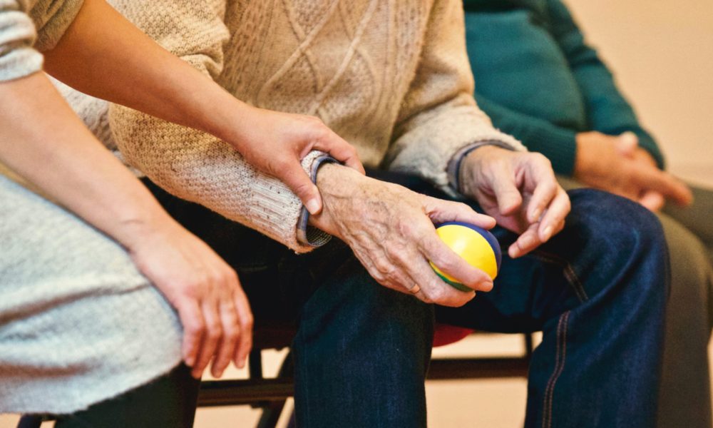 un grupo de ancianos sentados en sillas con una pelota en las manos.